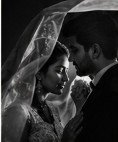 Couple under glowing bridal veil during quiet ceremonial pause
