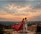 Bride and groom standing together on historic palace ramparts during golden hour